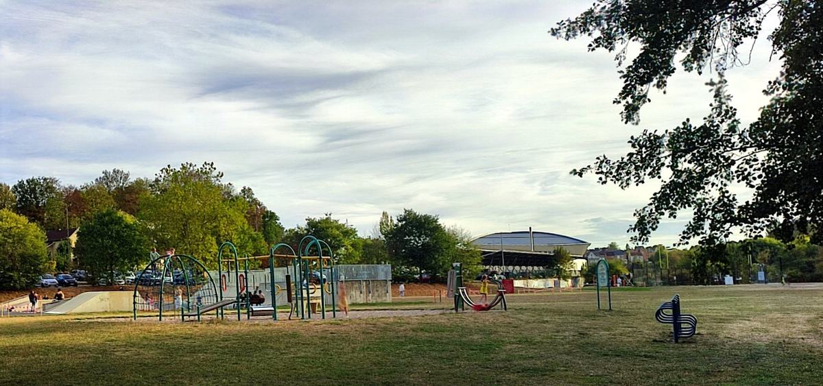 L’aire de jeux du parc du Mont-Olympe, avec le centre aquatique et son toit courbe à l’arrière-plan.