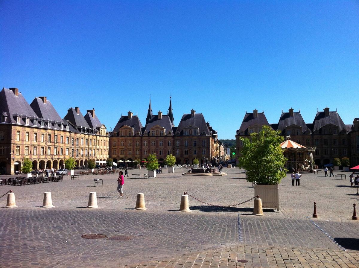 La Place Ducale de Charleville-Mézières : façades de brique et pierre à arcades, pavés et terrasses de café.